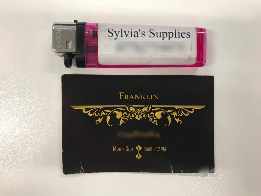 Picture of a lighter saying 'Sylvia's Supplies' and a card saying 'Franklin'. The numbers have been blurred.